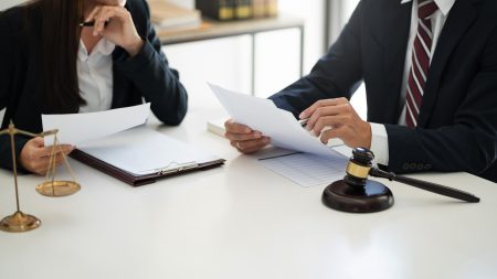 2 lawyers wearing black suits sat down having a conversation