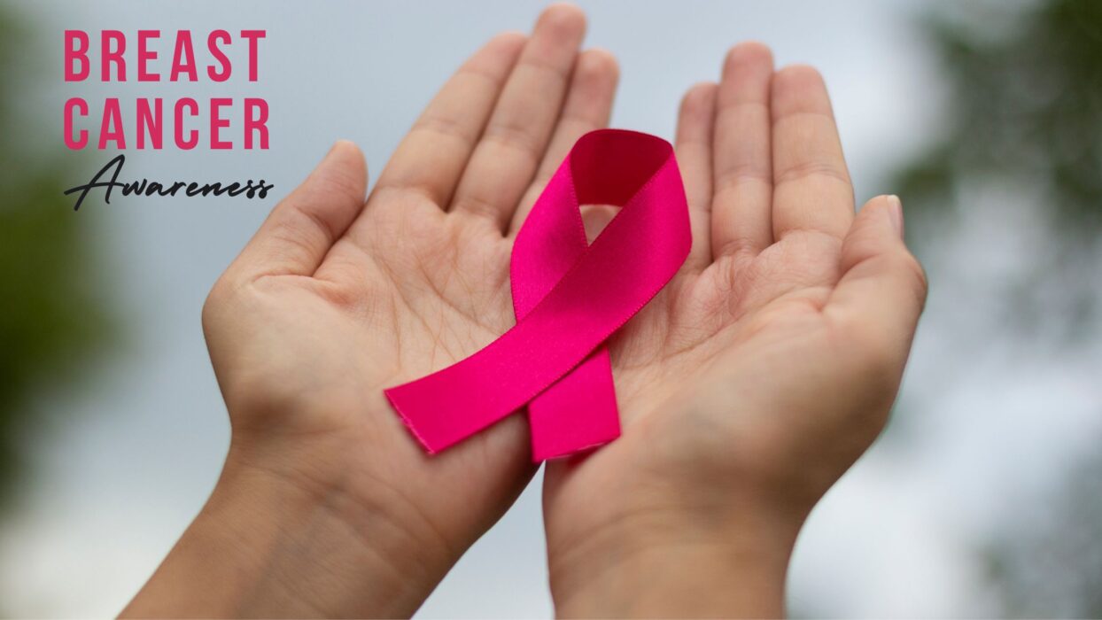 A person holding out a pink ribbon in their palms, with the Breast Cancer Awareness logo in the top left corner