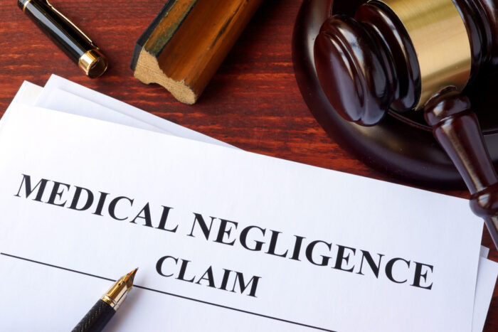 Medical negligence claim paperwork alongside a gavel and pen