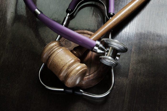Stethoscope and gavel together on top of a black table