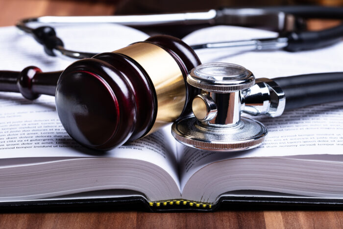 Stethoscope and a legal gavel sat on top of an open book.